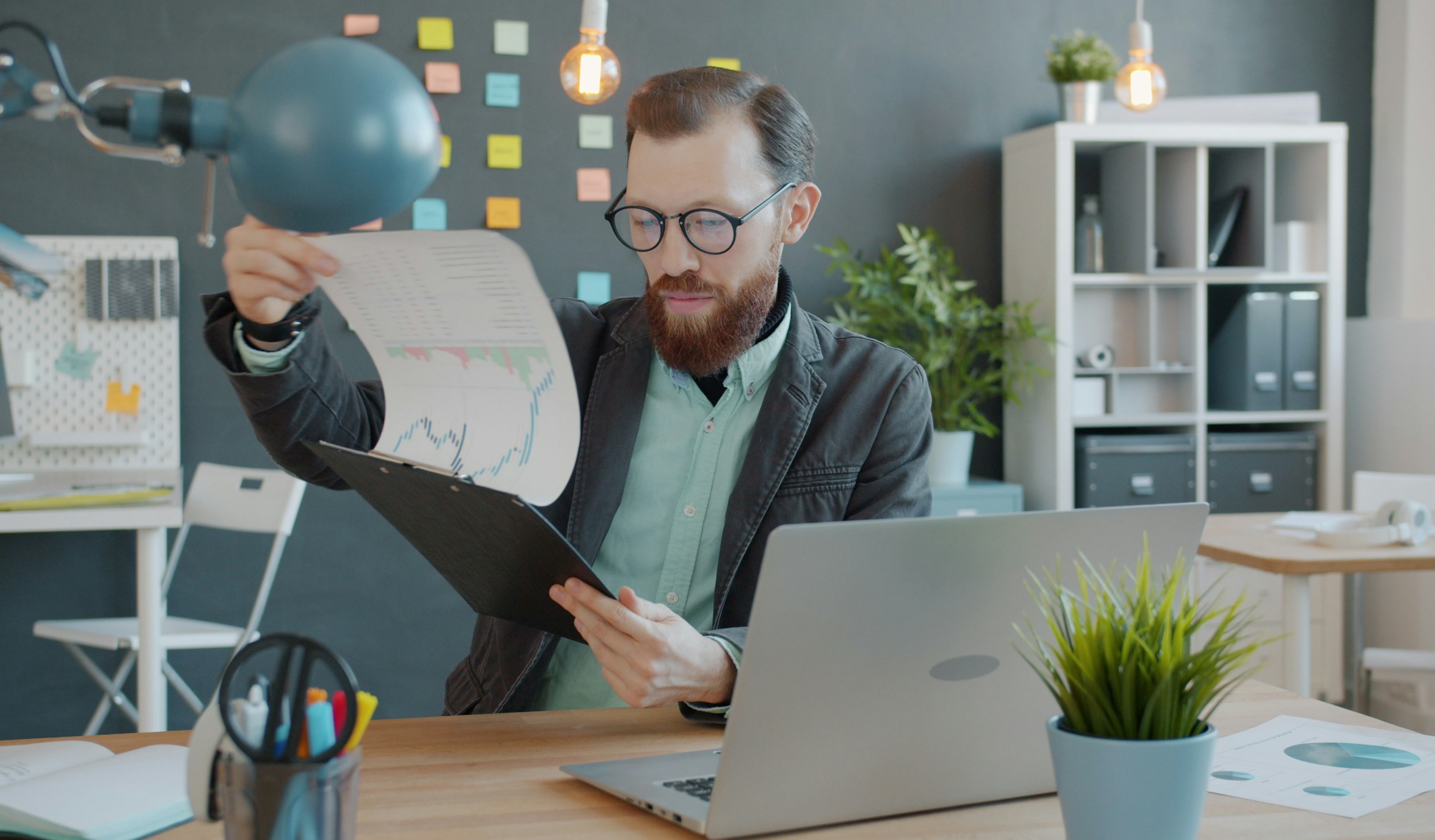 A person at an office desk working through printed documents