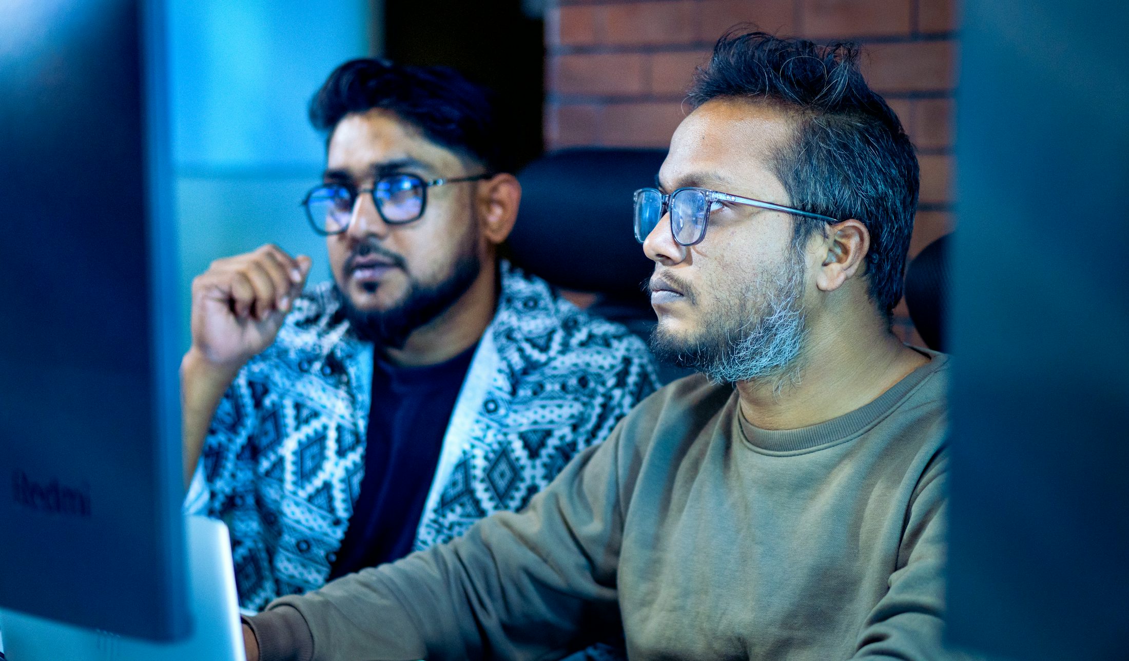 Two colleagues studying a set of figures on a computer screen
