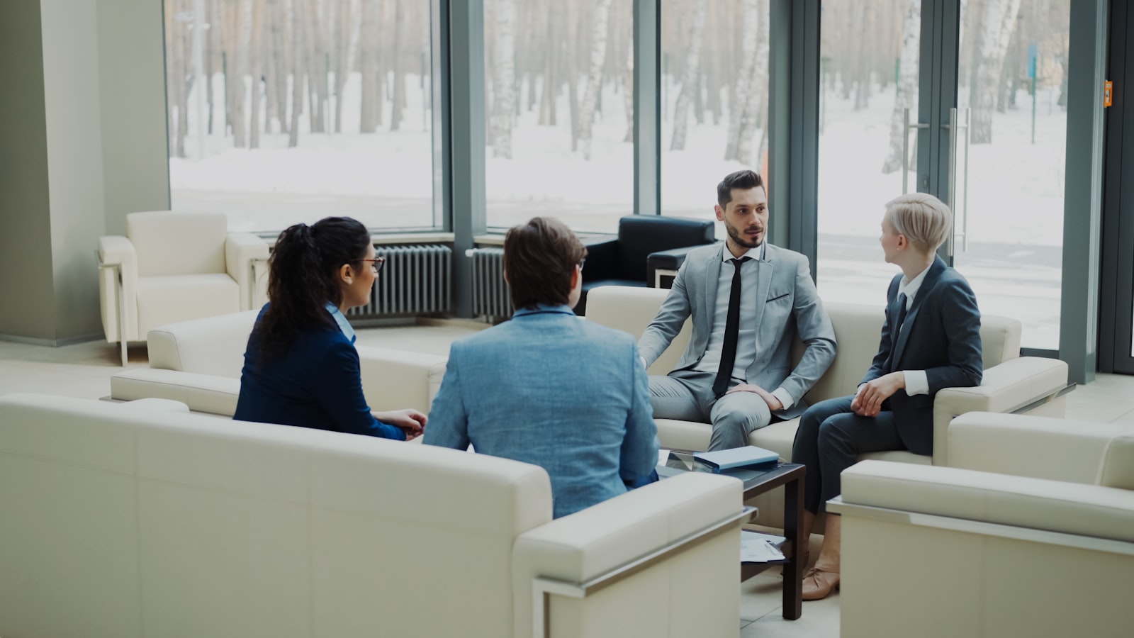 Four professionals discussing an agreement together in a modern office meeting space