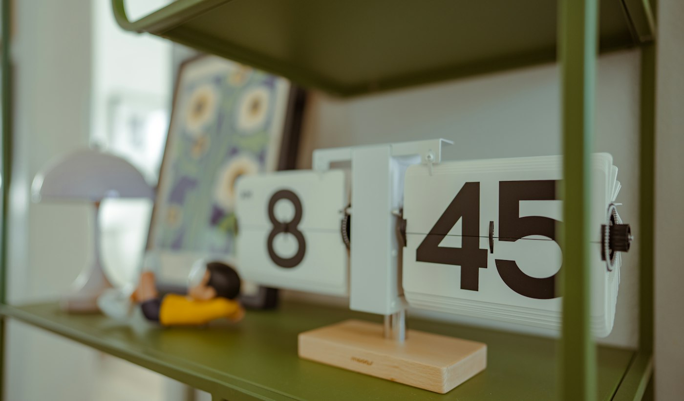 A flip clock showing eight forty five on a shelf