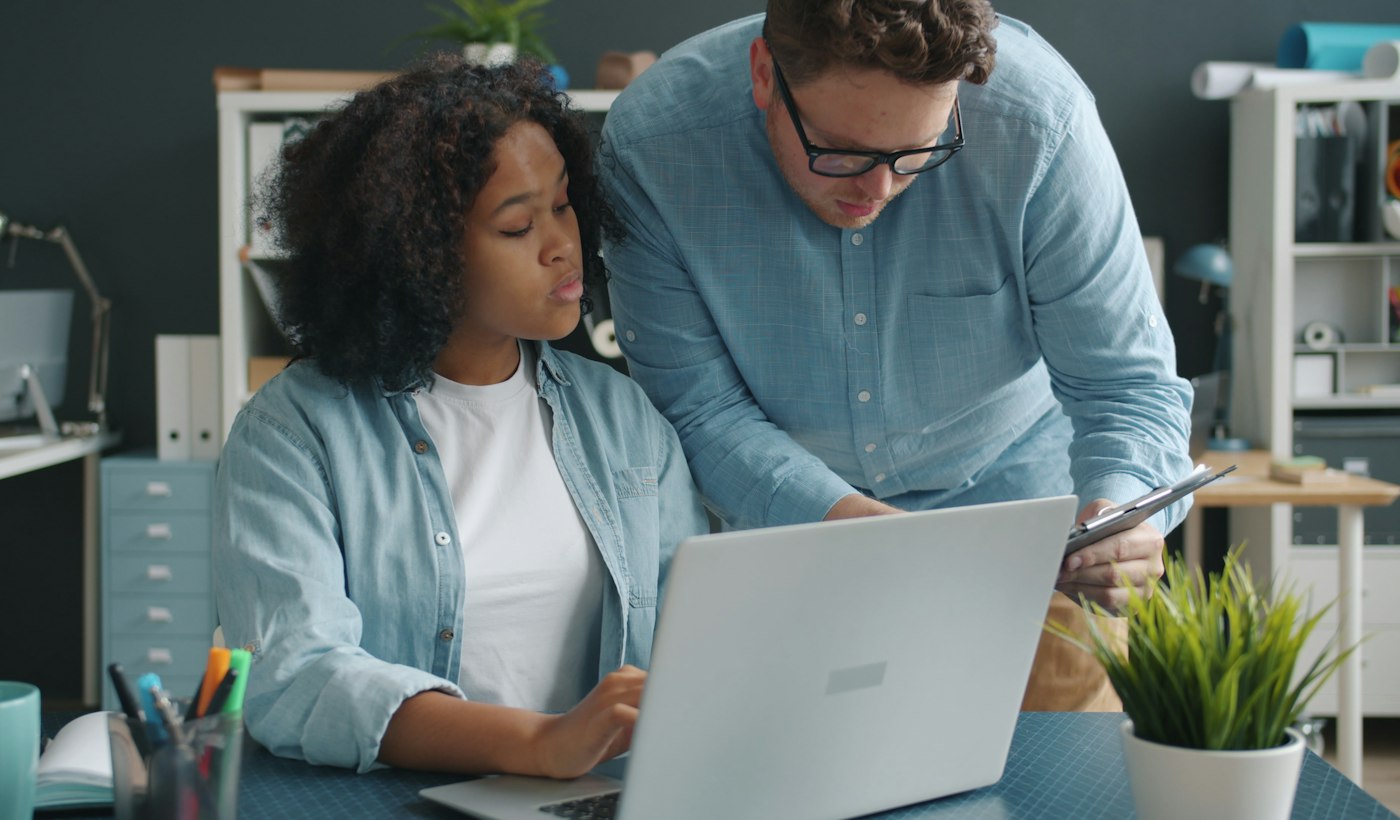 Two colleagues working through something together at a laptop